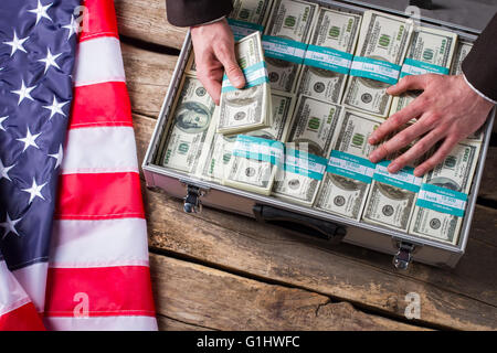 Hand touches dollars in suitcase. Stock Photo