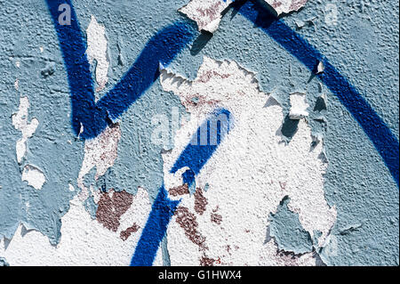 Graffiti and Peeling Paint on Wall Detail Background Stock Photo