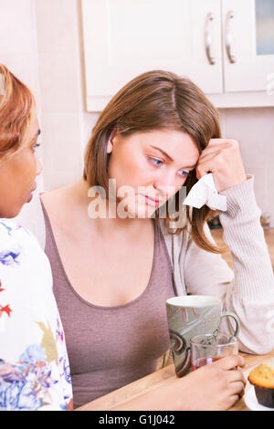 Sad young woman being comforted by friends Stock Photo