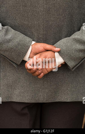 Mans hands clasped behind his back. Stock Photo