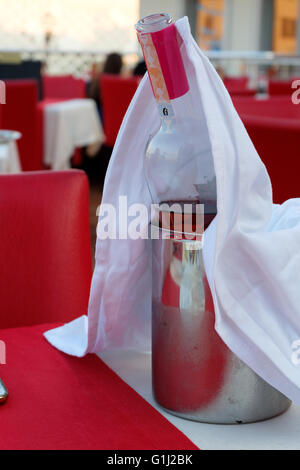 Close-up of an open bottle of wine in an iron bucket with ice. Stock Photo