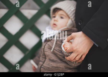 Father holding baby son's hand Stock Photo