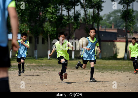(160517) -- SHANXI, May 17, 2016 (Xinhua) -- Students of Sima Primary School run for a football in Xiaoyi City, north China's Shanxi Province, May 17, 2016. Many village schools have set up more sports courses during these years as they are encouraged to add more physical education classes if conditions permit. A 2014 study found that 23 percent of Chinese boys under age 20 were overweight or obese, while the figure was 14 percent for girls.  (Xinhua/Zhan Yan) (wyl) Stock Photo
