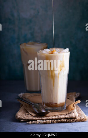 Ice coffee in glass mug with milk and cinnamon on wooden table in the  garden Stock Photo - Alamy