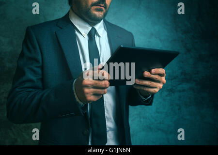 Businessman using digital tablet to read financial project report Stock Photo