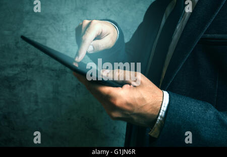 Businessman using digital tablet, finger pressing touch screen of modern electronic device. Stock Photo