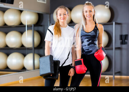 Portrait of two women at boxing training in fitness gym Stock Photo