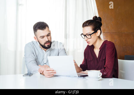 Portrait of two serious young businesspeople working together on business meeting Stock Photo
