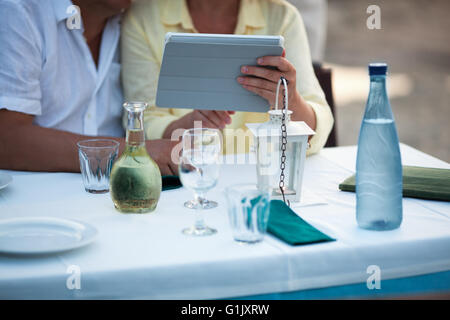 Middle-aged couple using a tablet at the table Stock Photo