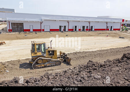 Earthmover with caterpillar is moving earth outdoors. Stock Photo