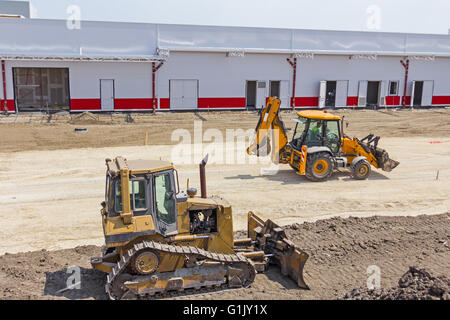 Earthmover with caterpillar is moving earth outdoors. Stock Photo