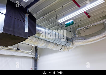 Ceiling with ventilation pipes for air condition and fire exit sign. Stock Photo