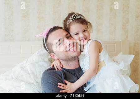 Cute little girl with her father wearing crowns Stock Photo