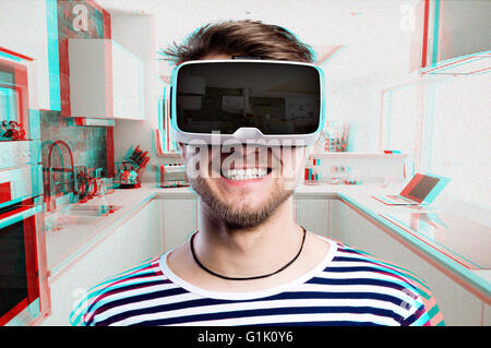 Man wearing virtual reality goggles. Home kitchen. Stock Photo