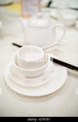 White tea pot and cups at a Chinese traditional dinner in a restaurant Stock Photo