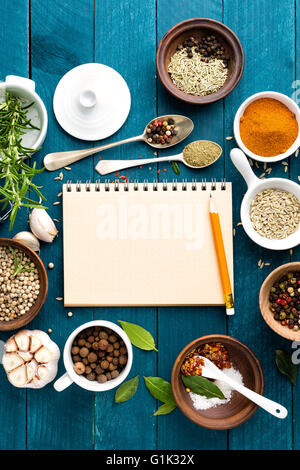 culinary background and recipe book with various spices on wooden table Stock Photo