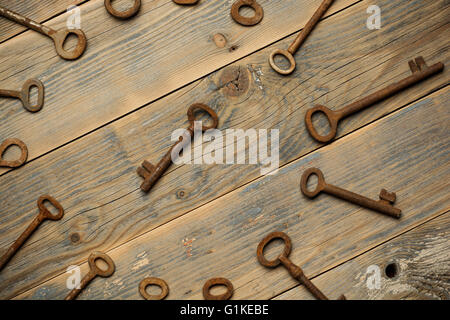 Antique copper keys on old wooden background Stock Photo