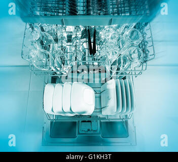 Open dishwasher with clean utensils in it. Stock Photo