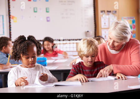 Elementary School Pupil With Teacher In Computer Class Stock Photo - Alamy