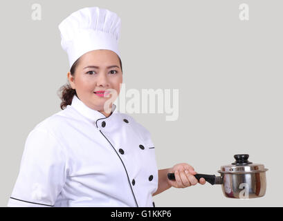 young woman chef in white uniform and white hat Stock Photo