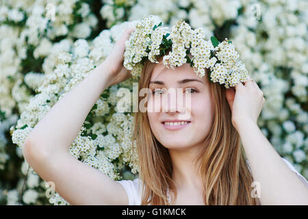 beautiful woman walking in the park near the white flowering trees Stock Photo