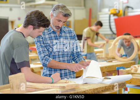 Teacher helping student in woodwork class Stock Photo