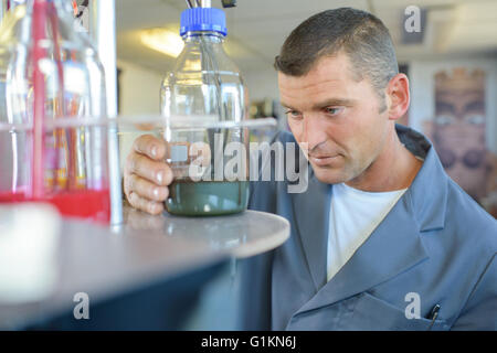 Man looking at glass jar Stock Photo