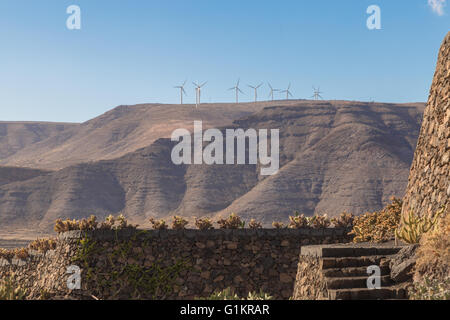 Wind turbines on a mountain top. Viewed from the Lanzarote Cactus Garden. Designed by César Manrique. Stock Photo