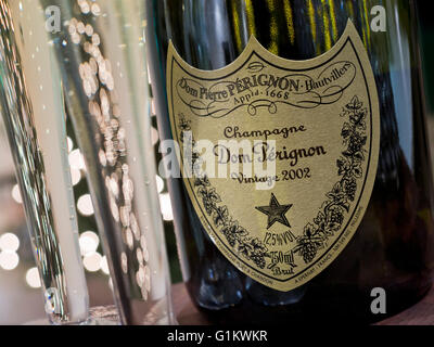 Freshly poured flutes of 2002  vintage Dom Perignon luxury champagne with sparkling lights in background Stock Photo