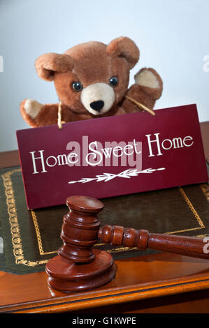House sale by auction/law concept, auctioneers hammer & 'Home Sweet Home' sign  with child's appealing teddy bear in support Stock Photo