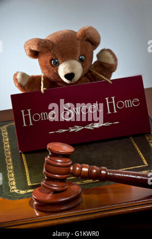 House sale by auction/law concept, auctioneers hammer & 'Home Sweet Home' sign with child's appealing teddy bear in support Stock Photo