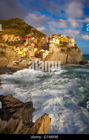 Swirling ocean at the foot of medieval town of Manarola in The Cinque Terre, Liguria Italy Stock Photo