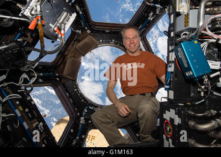 NASA astronaut Tim Kopra poses wearing his Texas shirt inside the cupola module onboard the International Space Station May 10, 2016 in Earth Orbit. Kopra, was born in Austin, Texas and is the commander of Expedition 47 and previously served as a flight engineer during Expeditions 46 and 20. Stock Photo