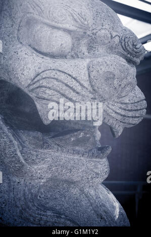 Granite sculpture of traditional chinese lion face close up selective focus Stock Photo