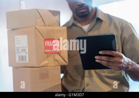 Black delivery man using digital tablet Stock Photo