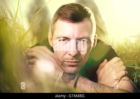 Caucasian man laying in grass Stock Photo