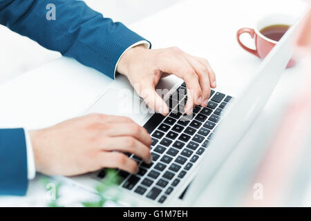 The male hands on the keyboard of laptop computer Stock Photo