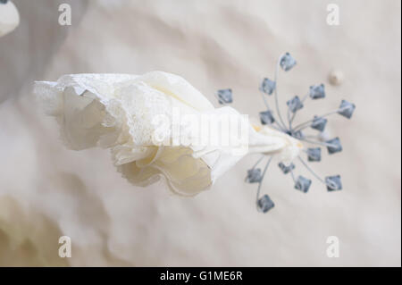 Wedding dress hanging on the chandelier. View from below. White ceiling. Stock Photo