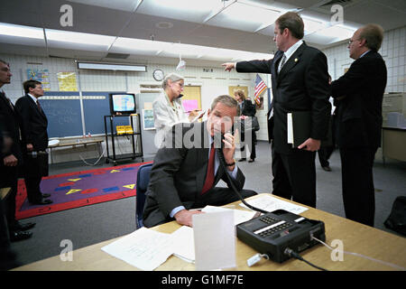 U.S President George W. Bush confers with staff via telephone as advisor Dan Bartlett points to news on the terror attacks in a secured classroom at Emma E. Booker Elementary School September 11, 2001 in Sarasota, Florida. Also pictured from left are: Deborah Loewer, Director of White House Situation Room, and Senior Adviser Karl Rove. Stock Photo