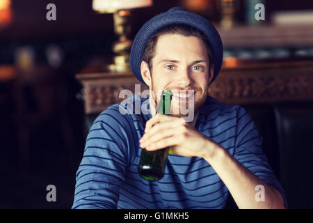 happy young man drinking beer at bar or pub Stock Photo