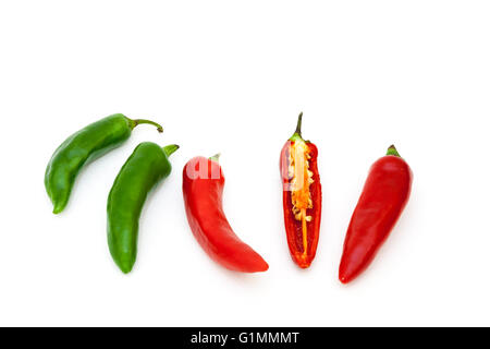 Five red and green chillies with one halved showing the seeds inside Stock Photo