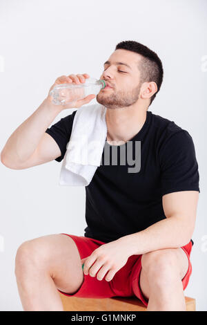 Young sportsman drinking water isolated on a white background Stock Photo