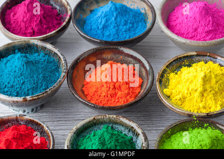Vivid colorful Holi dye powder in cups closeup. Shallow depth of field. Stock Photo