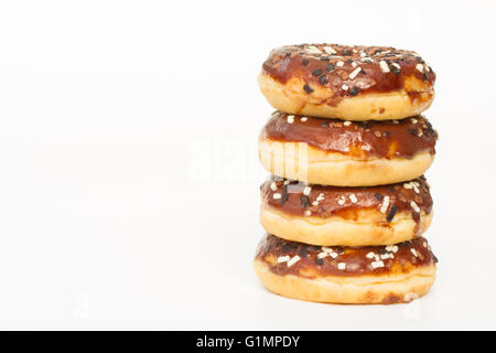 A stack of doughnuts with chocolate icing and sprinkles on an isolated white background. Stock Photo