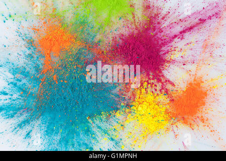 Color explosion concept. Colorful Holi powder exploding on white background closeup. Stock Photo