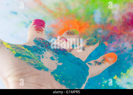 Open hand painted with Holi powder with blurred colorful background Stock Photo