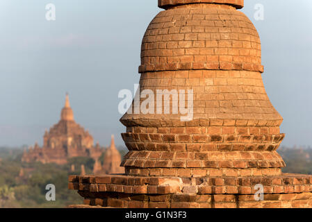 Small stupa atop the terrace of Pyathada Paya with Htilominlo Temple in the background, Bagan, Burma - Myanmar Stock Photo