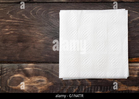 White paper napkins on dark wooden table surface Stock Photo