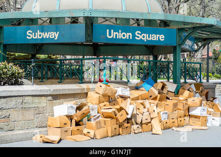 Discarded rubbish cardboard boxes piled up in front of Union Square subway station in Manhattan, New York Stock Photo