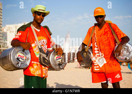 Matte Leao seller in Ipanema beach, Rio de Janeiro, Brazil - Matte Leao is a very popular Brazilian tea brand, now owned by The Coca-Cola Company - since the 1950s, in the scorching heat of Rio de Janeiro, the home-made iced tea is sold by street vendors in drums on the beach. Stock Photo